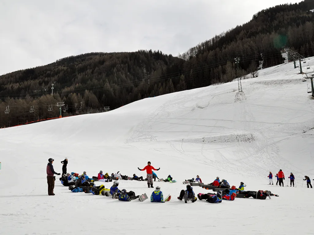 Skigruppe macht Pause auf der weiten Wiese.
